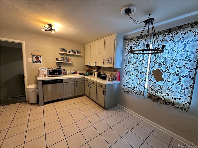 kitchen with hanging light fixtures, gray cabinets, light tile patterned floors, a textured ceiling, and appliances with stainless steel finishes