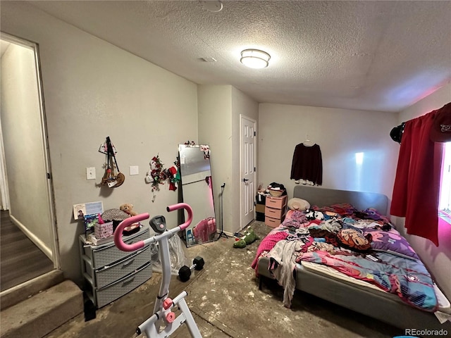 bedroom with fridge and a textured ceiling