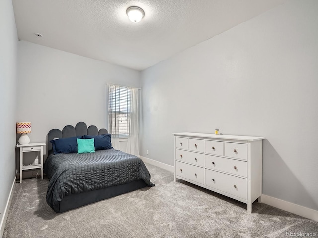 carpeted bedroom with a textured ceiling and baseboards