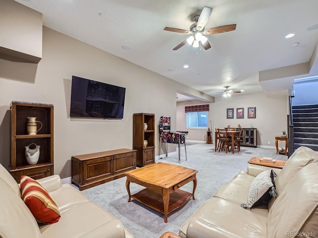 living room with stairway, a ceiling fan, baseboards, recessed lighting, and light carpet