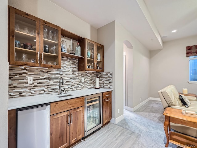 bar featuring a sink, backsplash, fridge, wine cooler, and wet bar