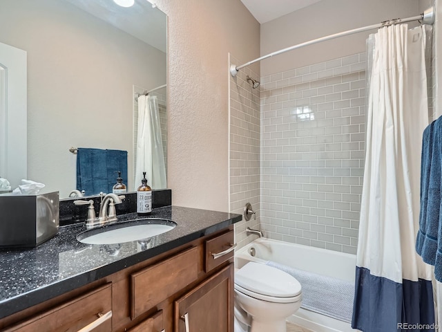 full bathroom with shower / bath combo with shower curtain, toilet, vanity, and a textured wall