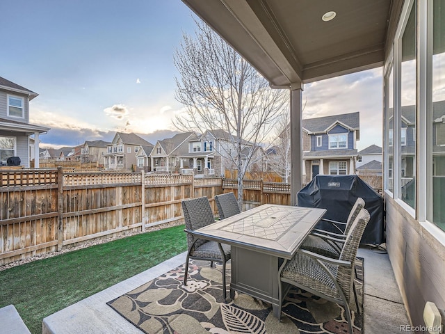 view of patio / terrace featuring a residential view, a grill, outdoor dining area, and fence