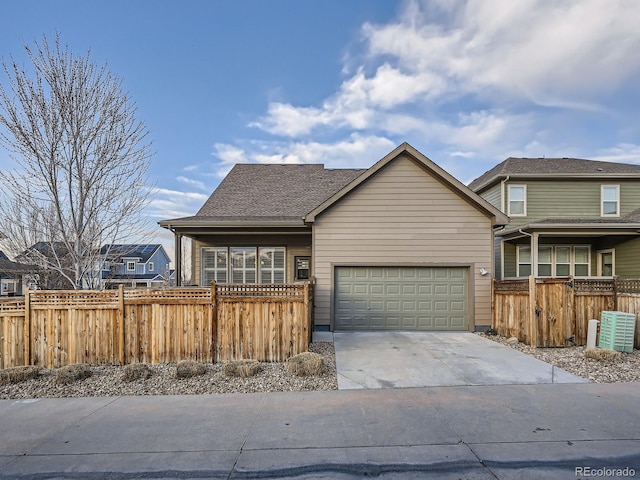 view of front of home featuring an attached garage, fence, and driveway