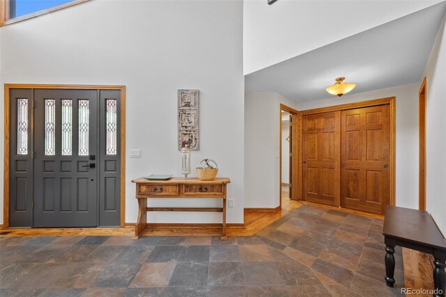 9 Red Fox Ln, Littleton, CO 80127 - foyer featuring baseboards, a high ceiling, and stone finish floors