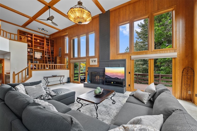 9 Red Fox Ln, Littleton, CO 80127 - living room featuring carpet floors, wooden walls, a high ceiling, built in shelves, and a fireplace
