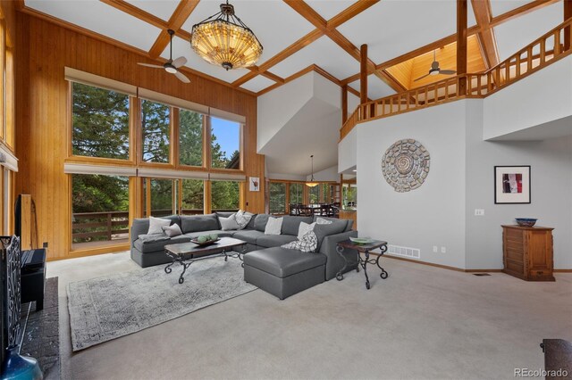 9 Red Fox Ln, Littleton, CO 80127 - carpeted living room with ceiling fan, a towering ceiling, baseboards, beamed ceiling, and wood walls