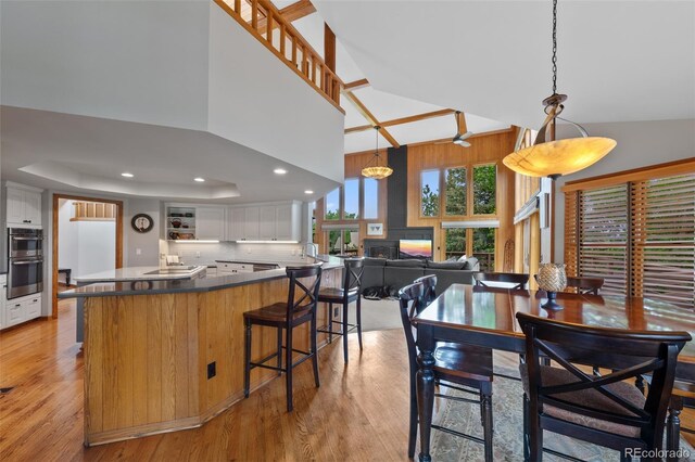 9 Red Fox Ln, Littleton, CO 80127 - dining area with light wood finished floors, high vaulted ceiling, recessed lighting, and a warm lit fireplace