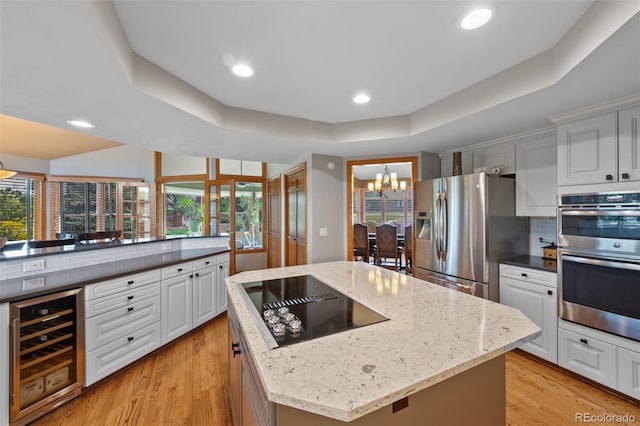 9 Red Fox Ln, Littleton, CO 80127 - kitchen featuring wine cooler, appliances with stainless steel finishes, decorative backsplash, a chandelier, and a center island