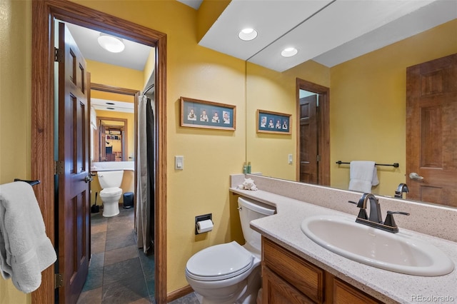 9 Red Fox Ln, Littleton, CO 80127 - bathroom with toilet, vanity, stone finish floors, and recessed lighting