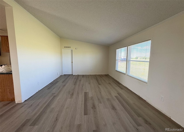15125 Ewing Ct, Peyton, CO 80831 - spare room featuring a textured ceiling, lofted ceiling, and wood finished floors