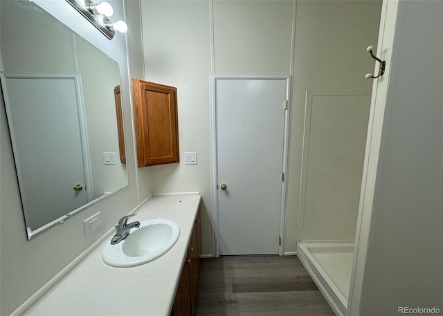 15125 Ewing Ct, Peyton, CO 80831 - bathroom with vanity, wood finished floors, and a stall shower