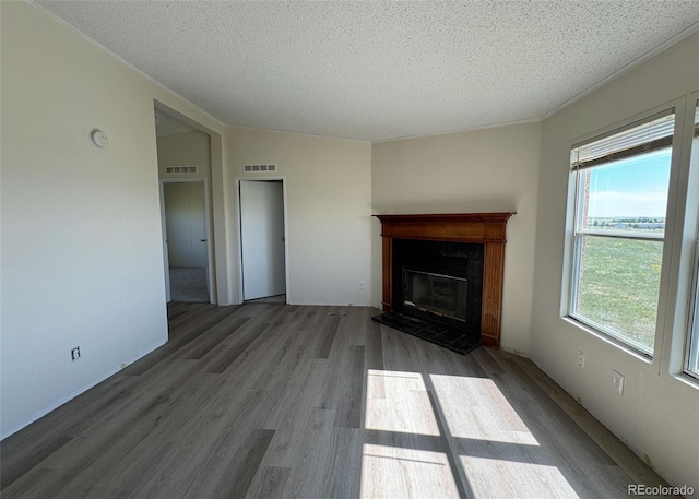 15125 Ewing Ct, Peyton, CO 80831 - unfurnished living room with a fireplace with raised hearth, a textured ceiling, and wood finished floors