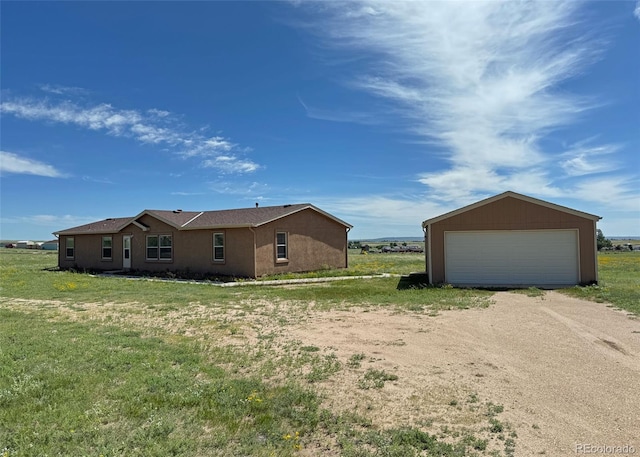 15125 Ewing Ct, Peyton, CO 80831 - view of property exterior with a detached garage, an outdoor structure, stucco siding, and a lawn