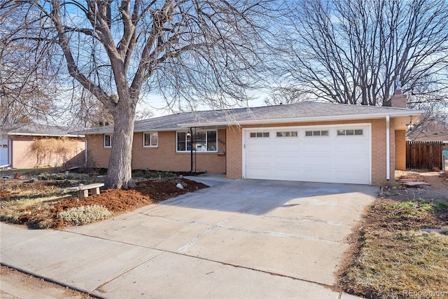 single story home featuring a garage, driveway, brick siding, and a chimney