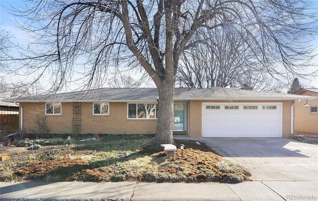 single story home with a garage, brick siding, and driveway