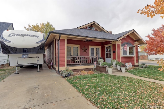 view of front of house with ceiling fan, a front yard, and covered porch