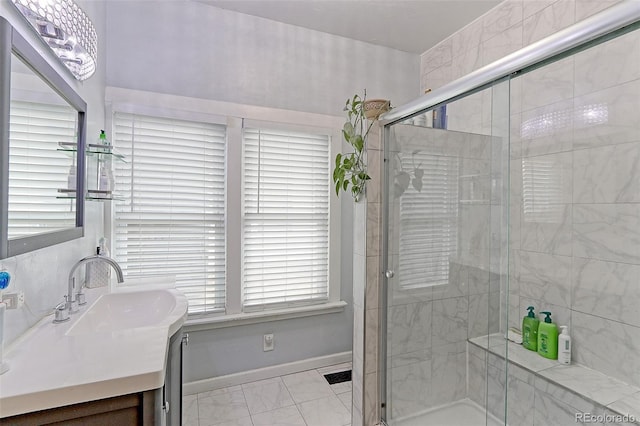 bathroom featuring a shower with door and vanity