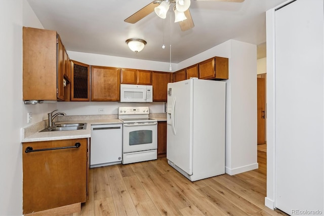 9340 E Center Ave Unit 1A, Denver, CO 80247 - kitchen with white appliances, a sink, brown cabinets, ceiling fan, and light wood-style flooring