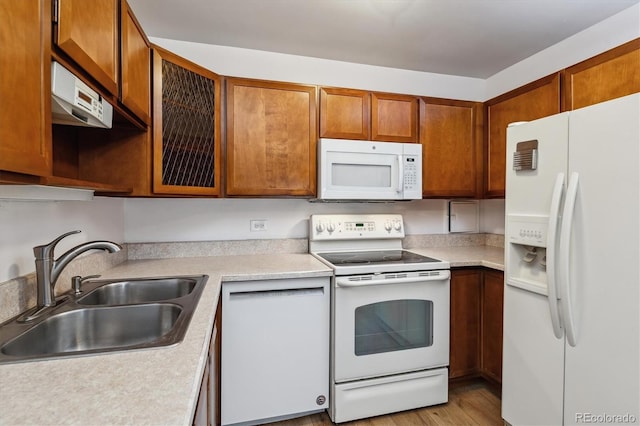 9340 E Center Ave Unit 1A, Denver, CO 80247 - kitchen featuring white appliances, a sink, light countertops, brown cabinets, and light wood-style flooring
