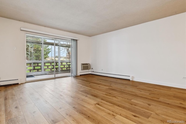 9340 E Center Ave Unit 1A, Denver, CO 80247 - spare room featuring hardwood / wood-style flooring, a wall unit AC, and a baseboard radiator
