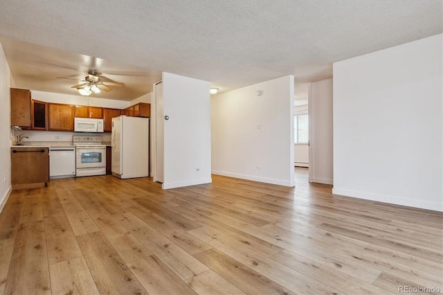 9340 E Center Ave Unit 1A, Denver, CO 80247 - unfurnished living room featuring light wood finished floors, baseboards, ceiling fan, baseboard heating, and a sink