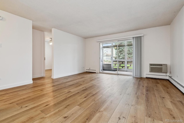 9340 E Center Ave Unit 1A, Denver, CO 80247 - unfurnished room with a baseboard heating unit, a wall mounted air conditioner, light wood-style flooring, and baseboards