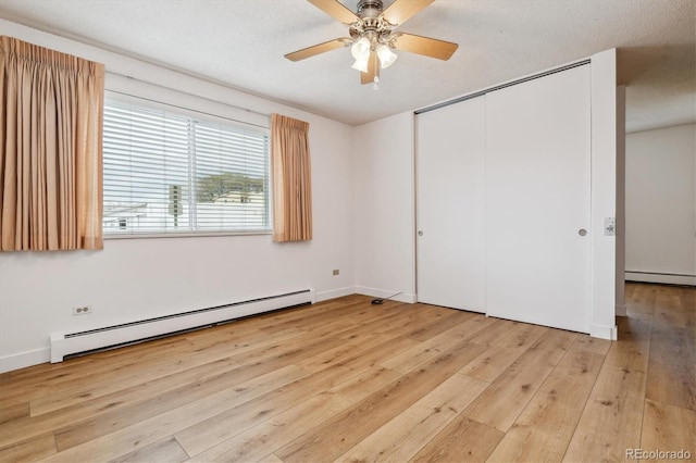9340 E Center Ave Unit 1A, Denver, CO 80247 - unfurnished bedroom with a baseboard heating unit, light wood-style floors, and a closet