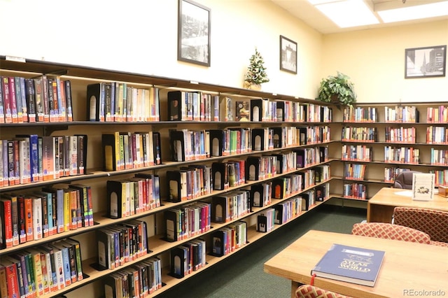 9340 E Center Ave Unit 1A, Denver, CO 80247 - living area featuring wall of books and carpet flooring