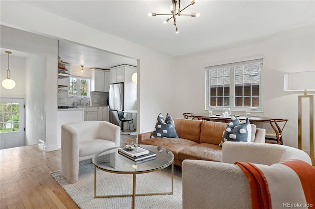 living area featuring a chandelier and light wood-style floors