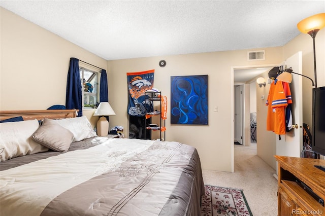 bedroom featuring a textured ceiling and light carpet