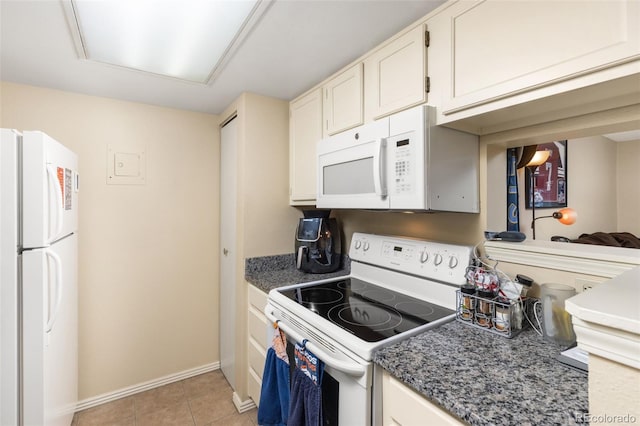 kitchen with white cabinetry, white appliances, and light tile patterned flooring