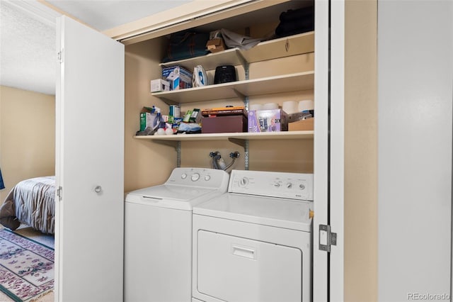 clothes washing area featuring a textured ceiling and washing machine and dryer