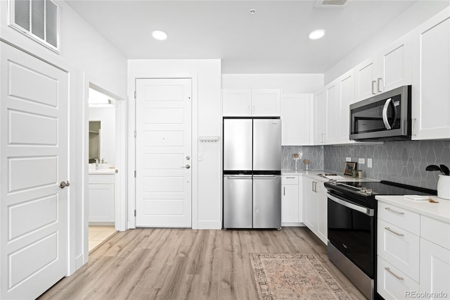 kitchen featuring stainless steel appliances, visible vents, and white cabinetry