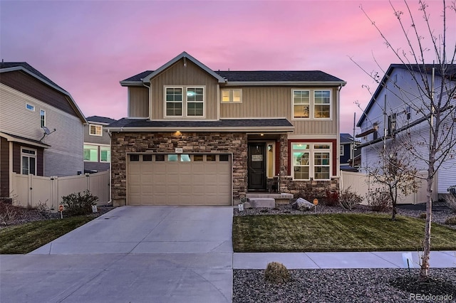 craftsman house with board and batten siding, fence, concrete driveway, a garage, and stone siding