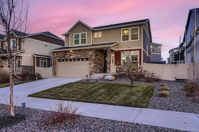 view of front of property featuring driveway, stone siding, fence, board and batten siding, and a garage