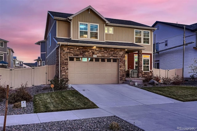 view of front of home featuring concrete driveway, an attached garage, fence, and stone siding