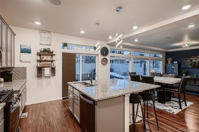 kitchen featuring a sink, range with gas cooktop, light stone countertops, dark wood-style floors, and stainless steel dishwasher