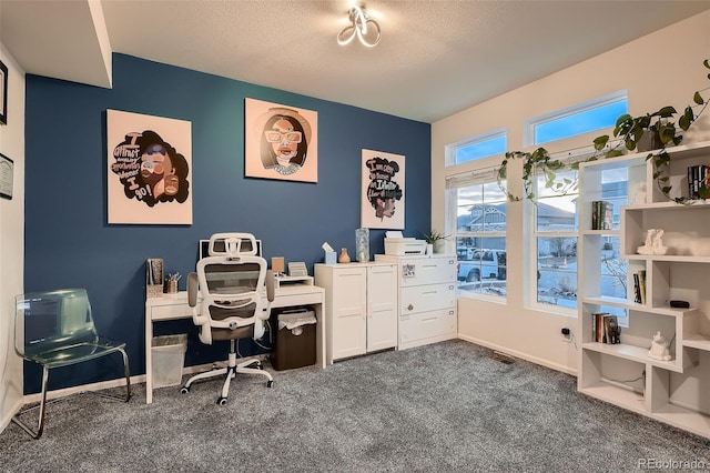 carpeted office space featuring a textured ceiling and baseboards