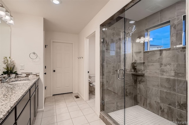 bathroom with visible vents, toilet, a stall shower, tile patterned flooring, and vanity