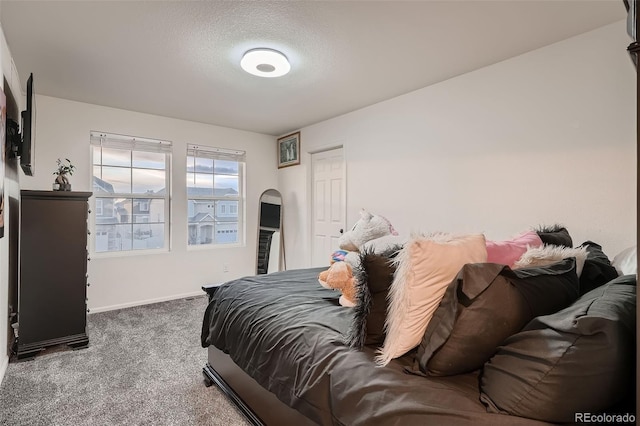 carpeted bedroom with arched walkways, a textured ceiling, and baseboards