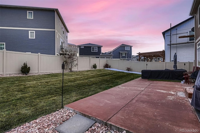 yard at dusk with a fenced backyard and a patio area