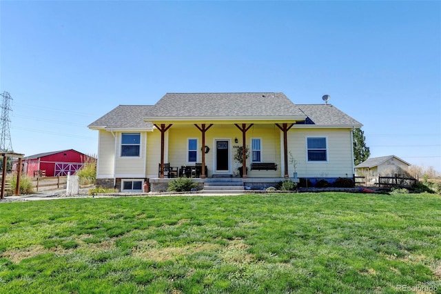 rear view of house featuring covered porch and a yard