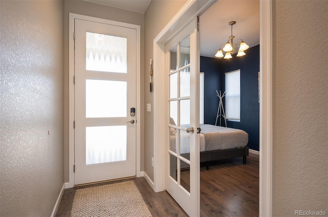 doorway featuring french doors, a chandelier, and dark hardwood / wood-style floors