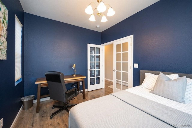 bedroom with an inviting chandelier, wood-type flooring, and french doors