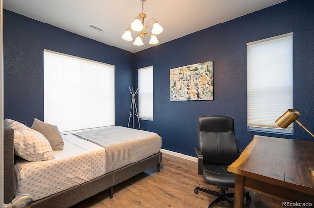 bedroom featuring a chandelier and wood-type flooring