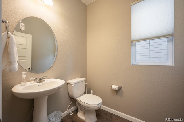 bathroom featuring hardwood / wood-style flooring and toilet