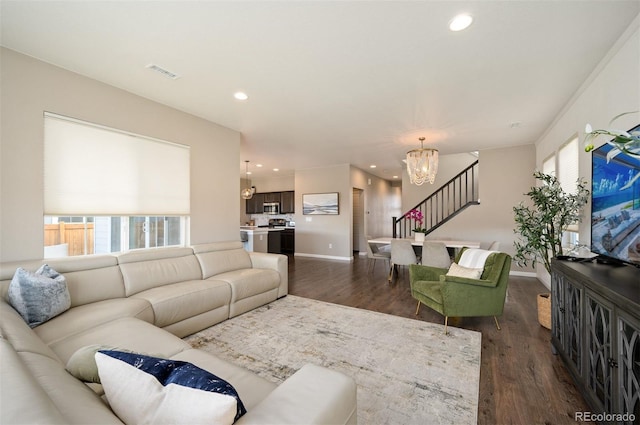 living room featuring dark wood-type flooring and an inviting chandelier