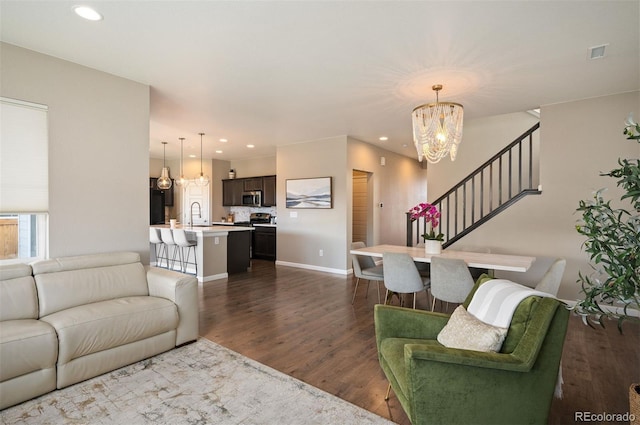 living room featuring dark hardwood / wood-style flooring, sink, and an inviting chandelier