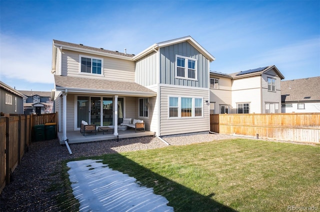 back of property featuring a patio area and a lawn